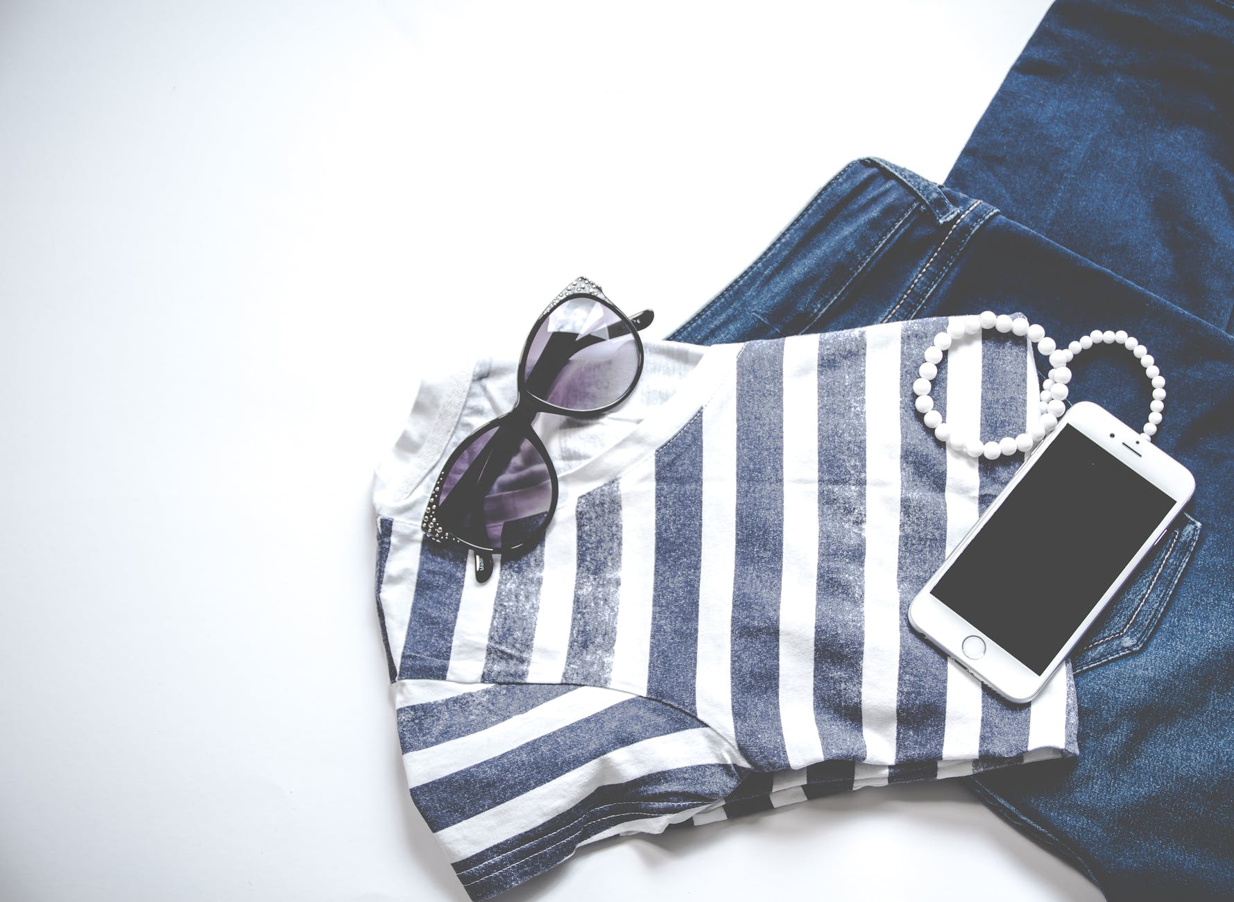 photo of iphone on shirt near sunglasses