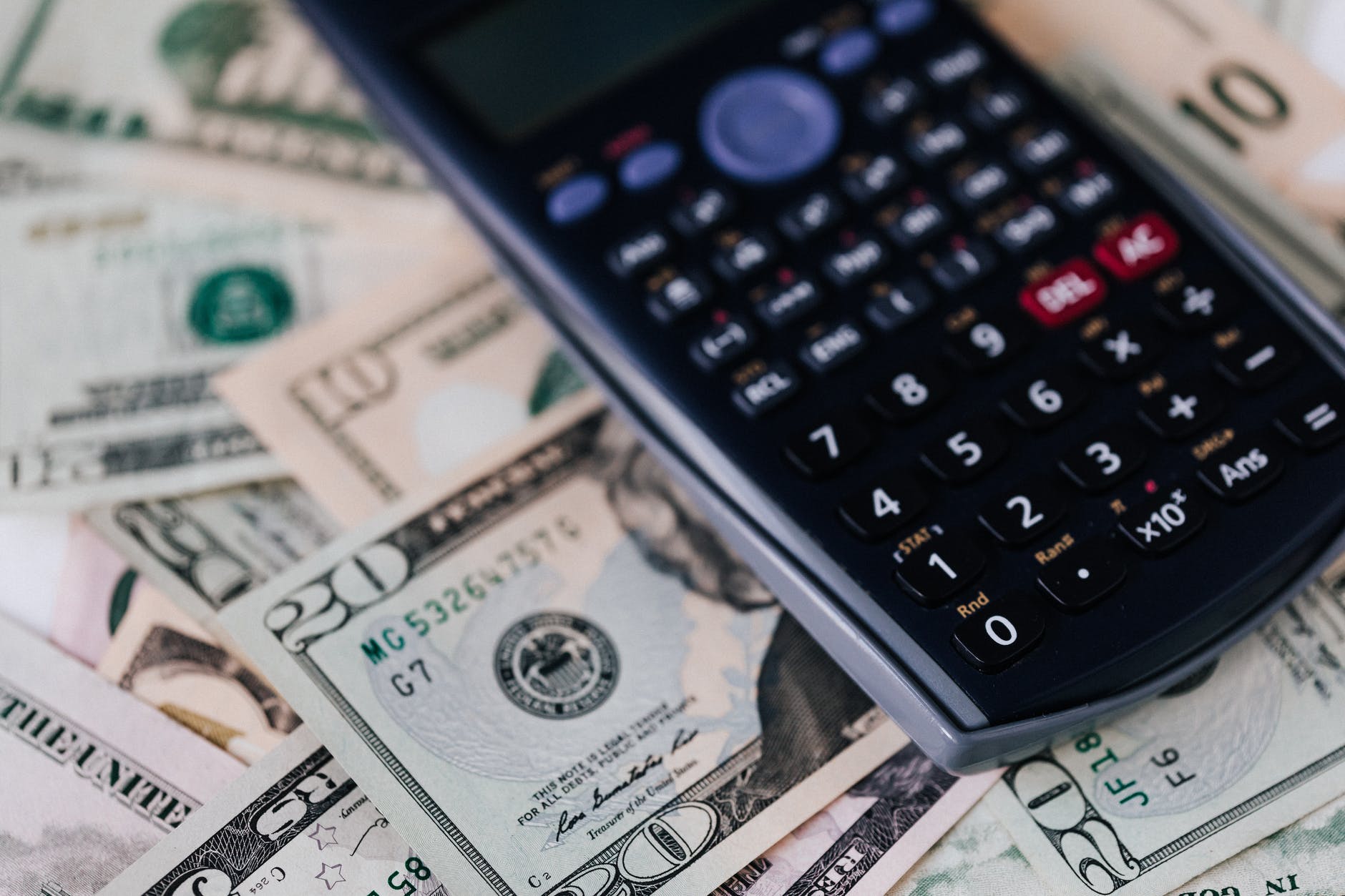 heap of united states dollar bills and calculator